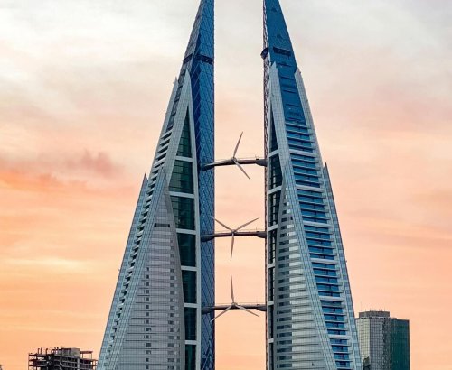 Stunning view of the Bahrain World Trade Center reflecting in the water at sunset.